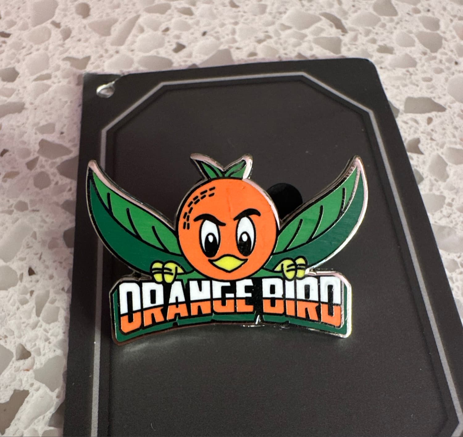 Orange Bird with Green Leaf Wings and 'ORANGE BIRD' Banner Pin front
