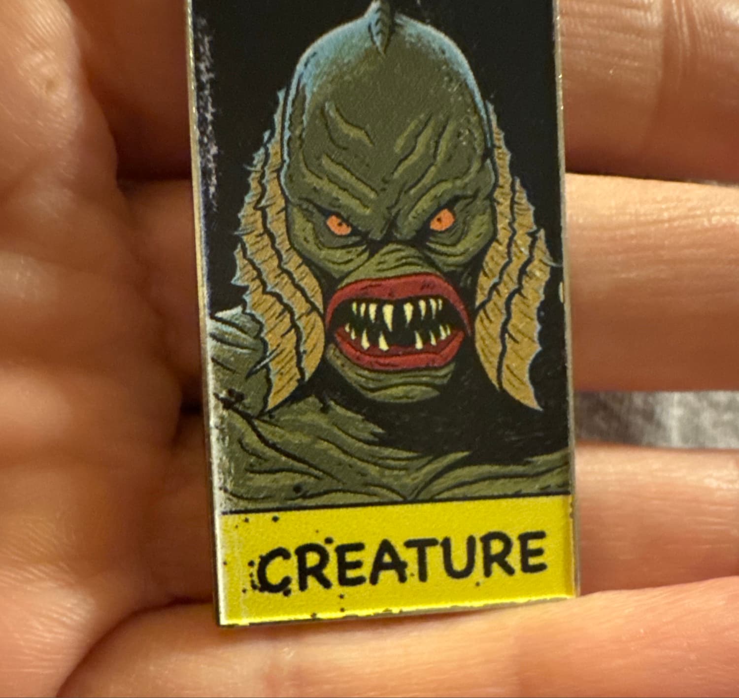 Creature from the Black Lagoon Enamel Pin with Yellow Banner front