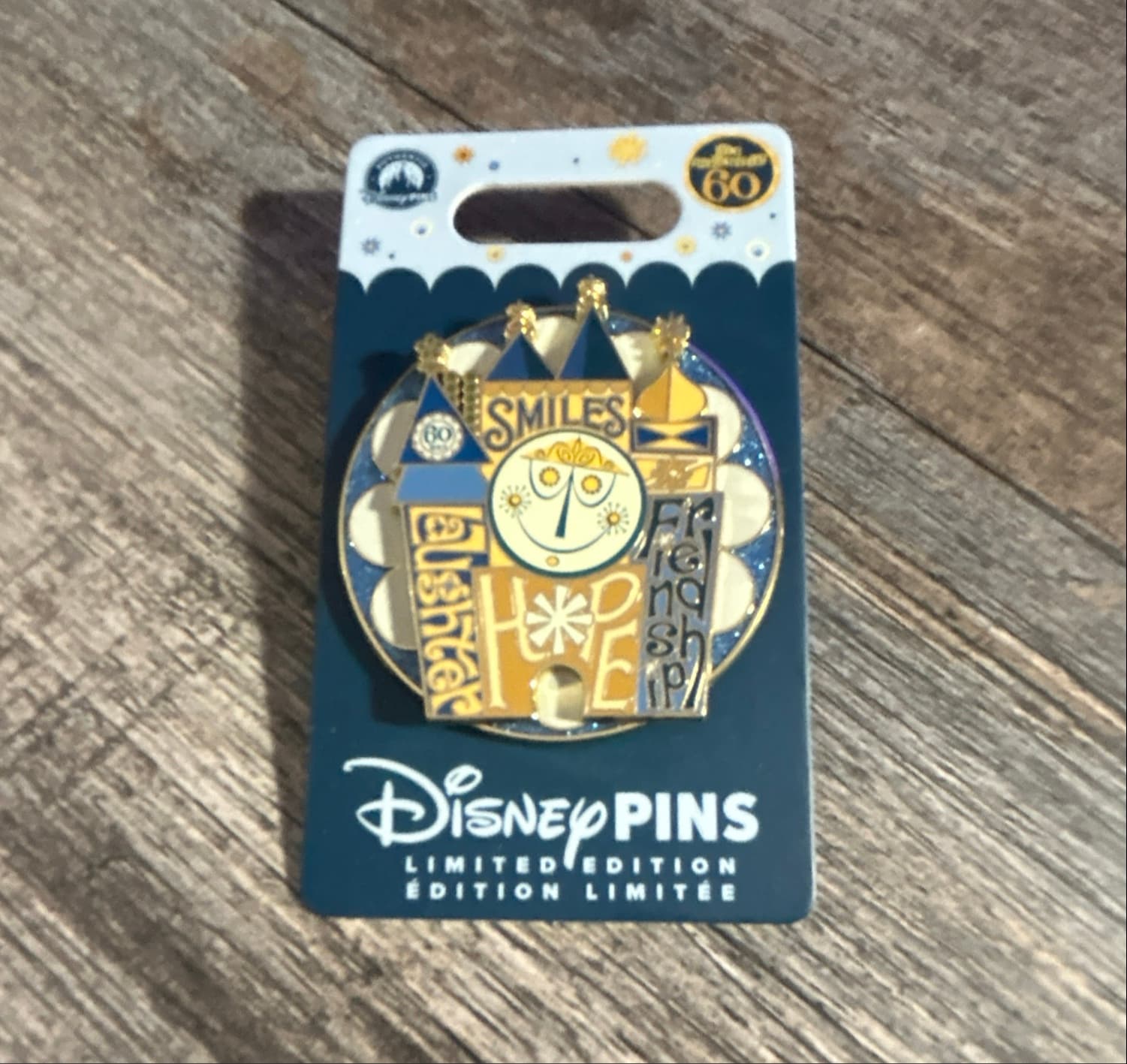 it's a small world 60th Anniversary Clock Face Pin with Smiles, Laughter, Hope, and Friendship front